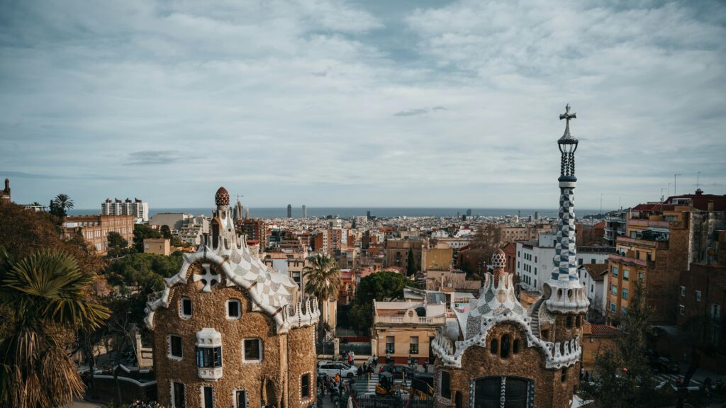 Opera Travel Experience Barcelona Scenic view of Park Güell's unique architecture overlooking Barcelona's cityscape as part of your Opera Travel Experience in Barcelona
