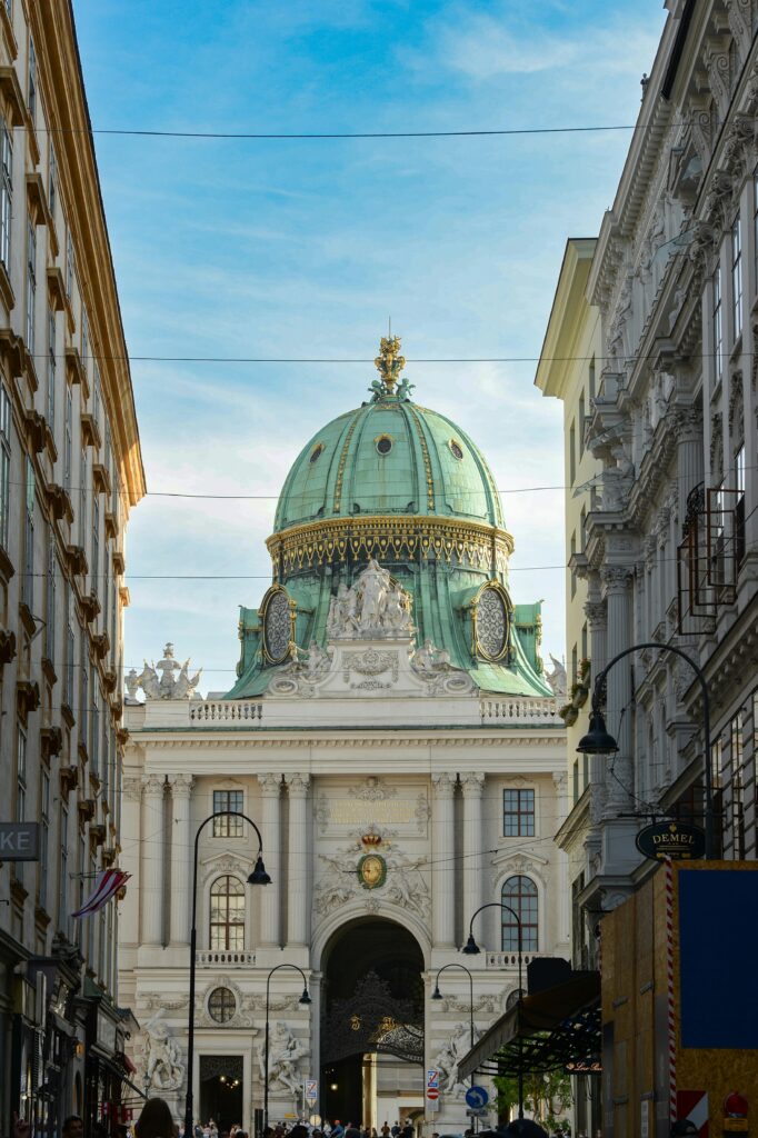 pexels-photo-34244093-34244093 The beautiful green dome of Hofburg Palace seen from a Vienna street, framed by historic architecture.