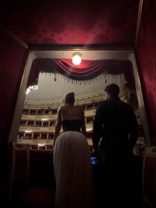 Elegant couple at an opera house in evening attire during winter