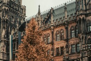 Beautiful decorated Christmas tree in front of gothic-style architecture, evoking holiday spirit.