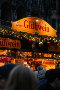 Festive glühwein stand at a Munich Christmas market, beautifully lit at night.