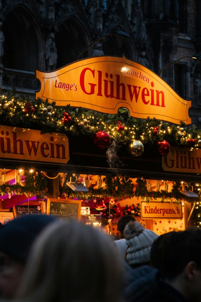 Festive glühwein stand at a Munich Christmas market, beautifully lit at night.